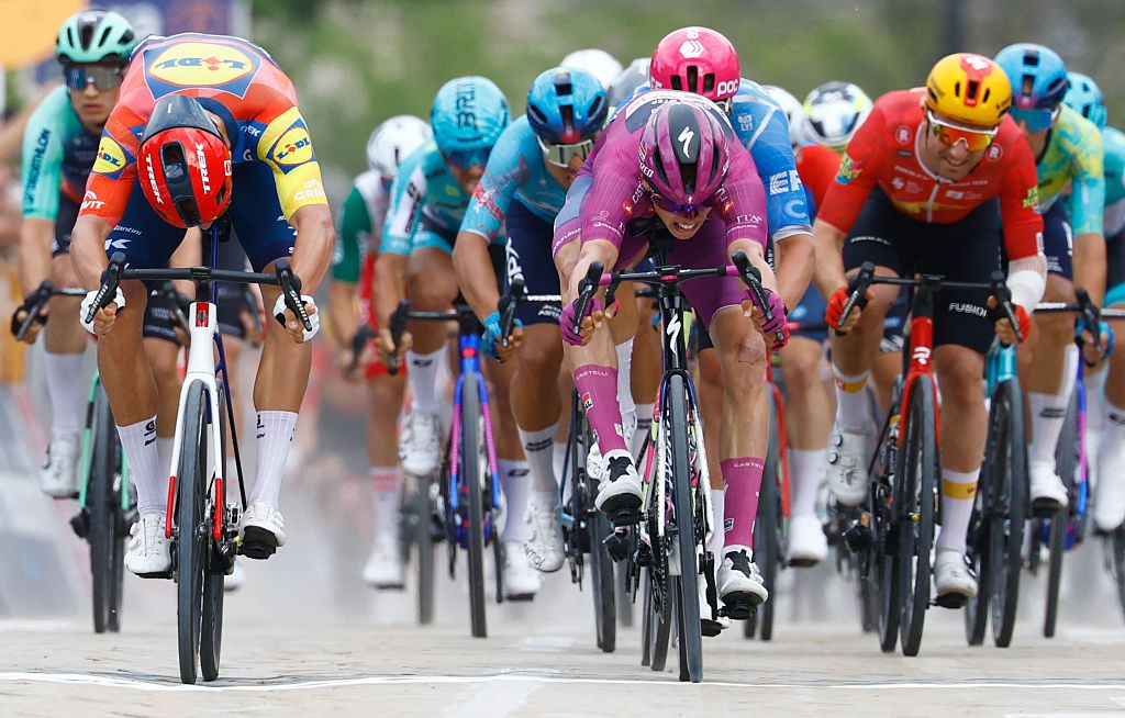 Paul Magnier (C) wearing the points classification mauve jersey (Maglia Ciclamino) sprint to win next to Lidl - Trek Italian rider Jonathan Milan in the 3nd stage of the Giro d'Italia 2026